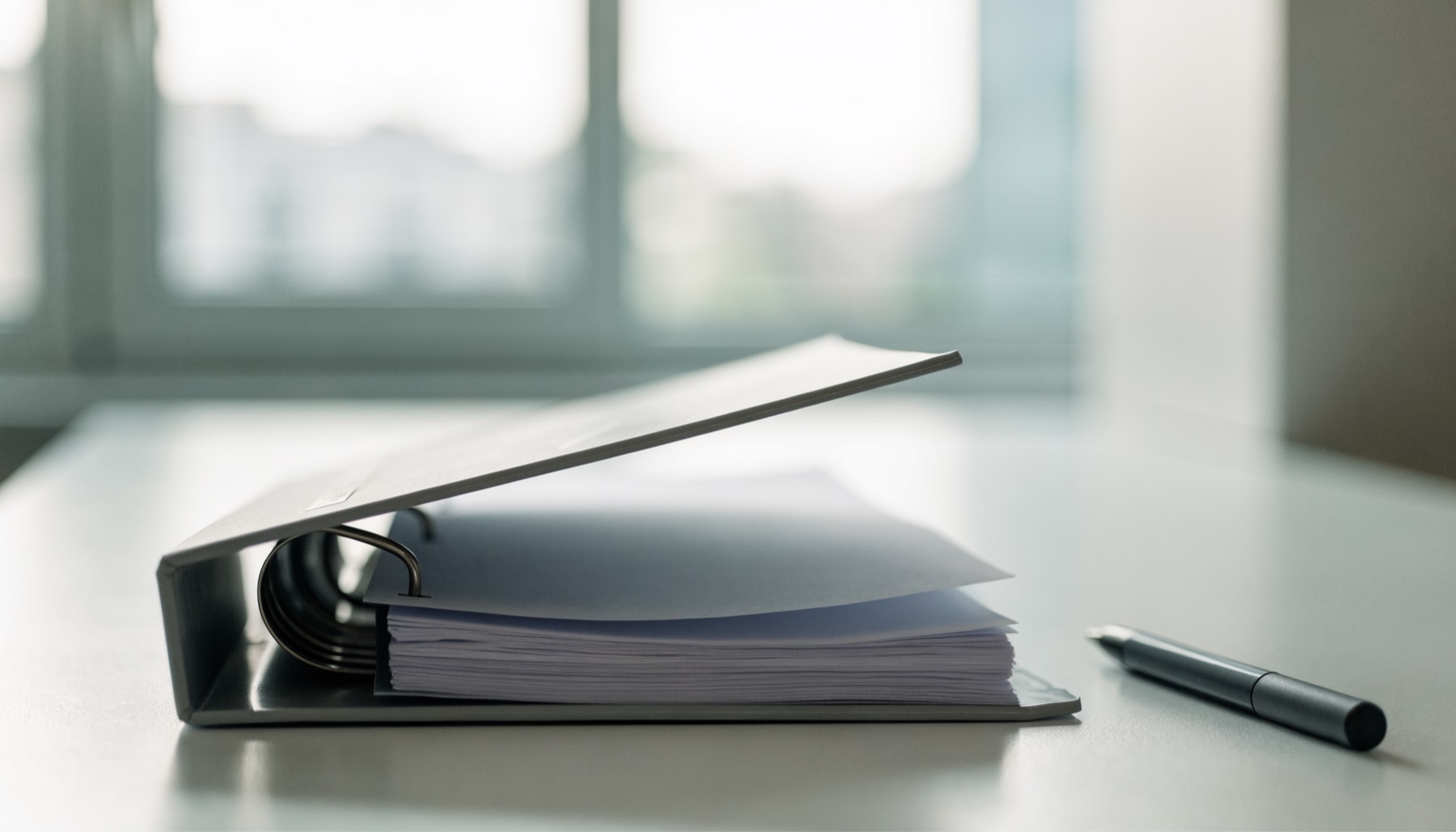 An open ring binder of blank pages on a clean laboratory bench